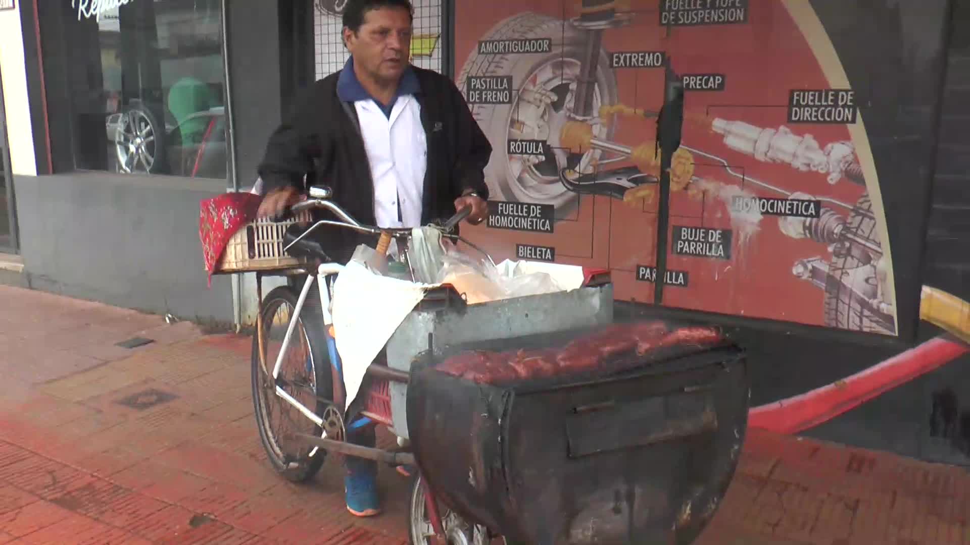 La otra cara de la crisis: montó una parrilla en su bicicleta para vender choripán